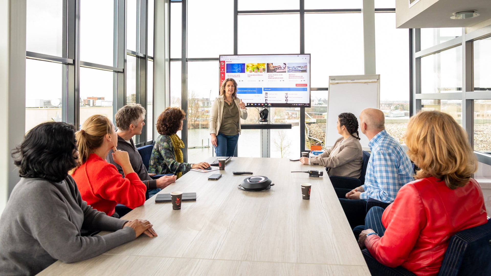Medewerkers in vergadering met 1 medewerker die een presentatie geeft