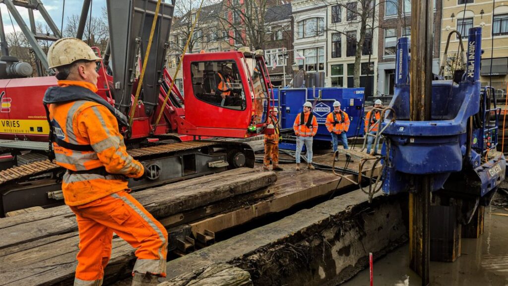 mensen aan het werk met groot materieel voor kadeherstel binnenstad Dordrecht